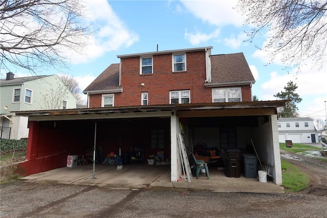 rear view of property with roof with shingles and brick siding