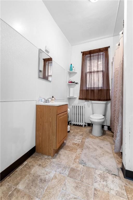 bathroom with radiator heating unit, vanity, and toilet