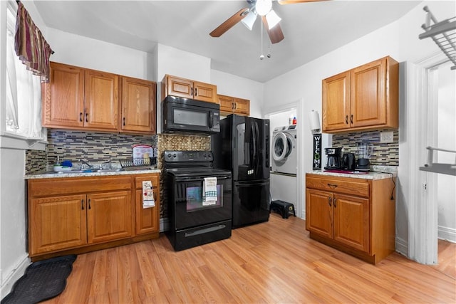 kitchen with black appliances, sink, ceiling fan, tasteful backsplash, and washer / clothes dryer