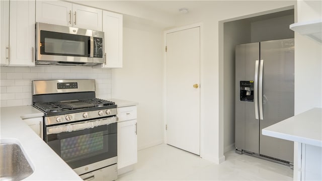 kitchen featuring white cabinetry, sink, appliances with stainless steel finishes, and tasteful backsplash