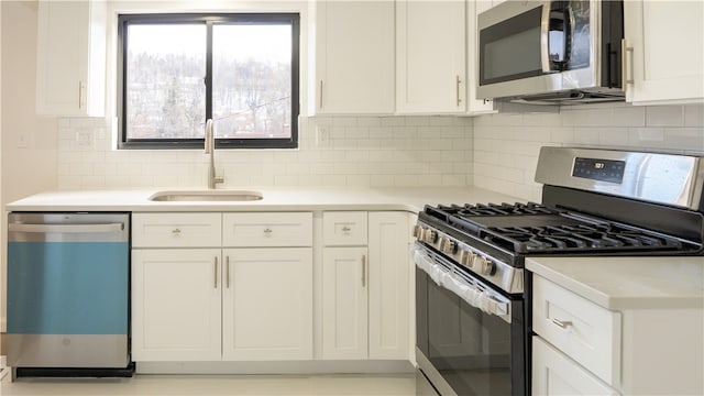 kitchen with backsplash, white cabinetry, sink, and appliances with stainless steel finishes