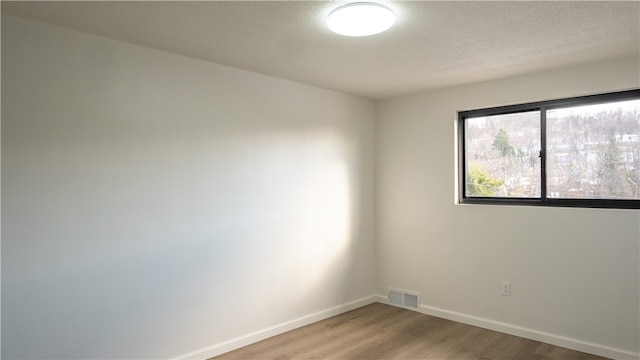 empty room featuring hardwood / wood-style floors and a textured ceiling