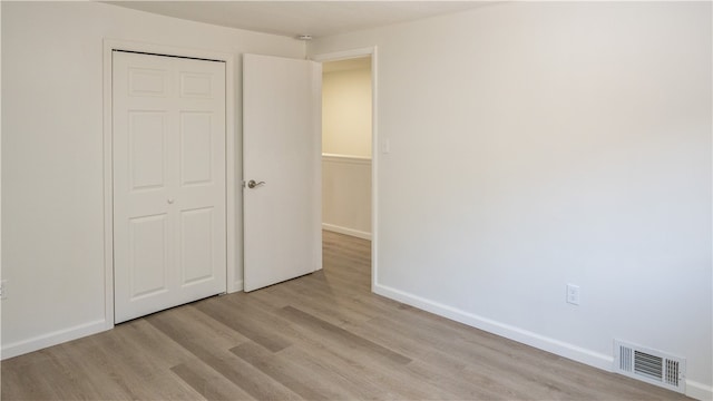 unfurnished bedroom featuring a closet and light wood-type flooring