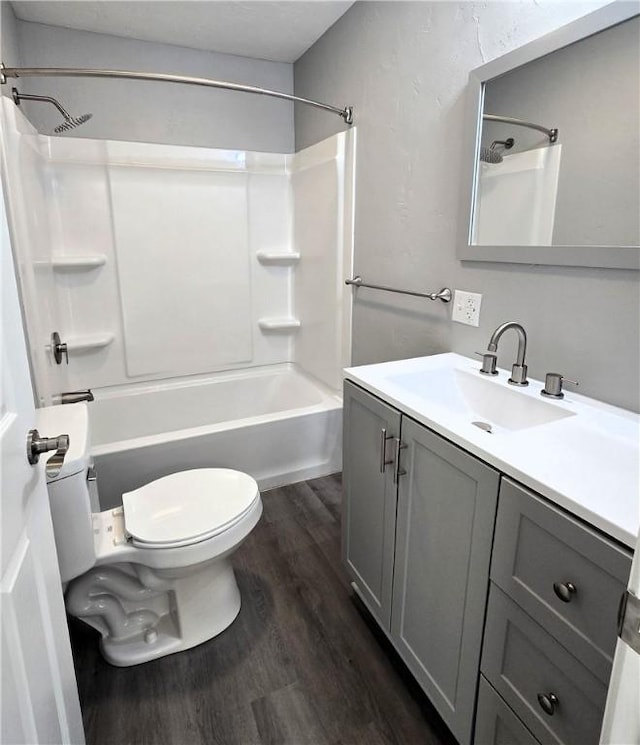 full bathroom featuring hardwood / wood-style flooring, shower / tub combination, vanity, and toilet