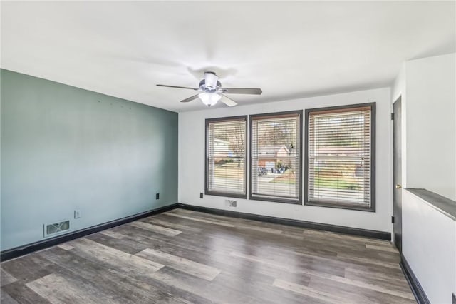 spare room featuring ceiling fan and dark wood-type flooring