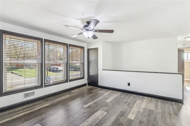 spare room with ceiling fan and dark hardwood / wood-style flooring