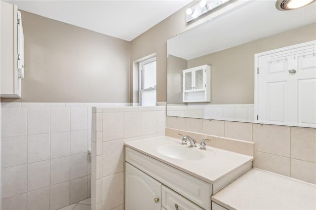 bathroom with vanity and tile walls