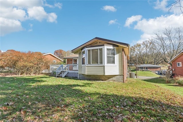 view of property exterior featuring central AC unit, a yard, and a wooden deck