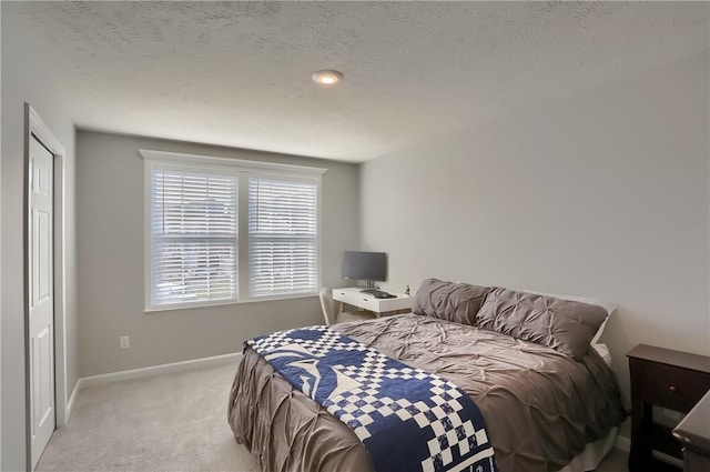 carpeted bedroom with a textured ceiling and a closet