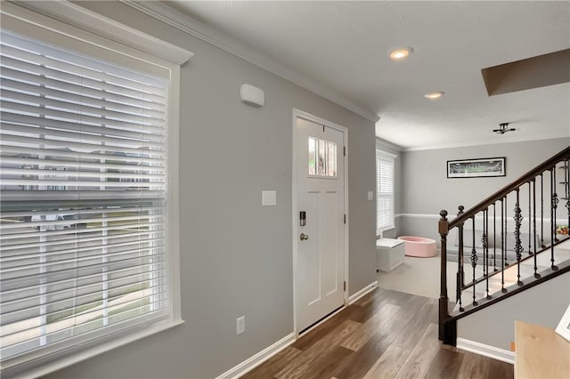 foyer entrance featuring ornamental molding and dark wood-type flooring