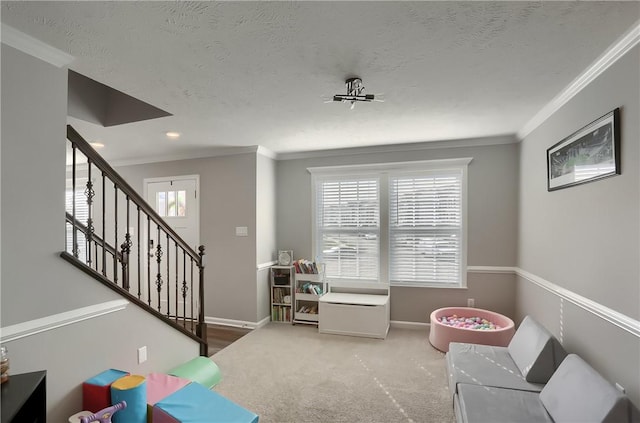 rec room featuring carpet flooring, plenty of natural light, ornamental molding, and a textured ceiling