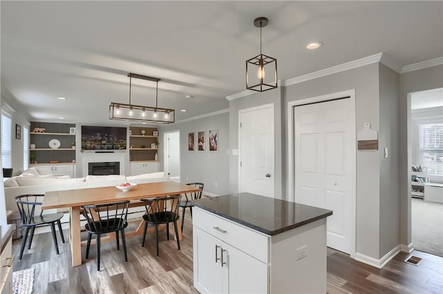 kitchen with a healthy amount of sunlight, white cabinetry, and hanging light fixtures