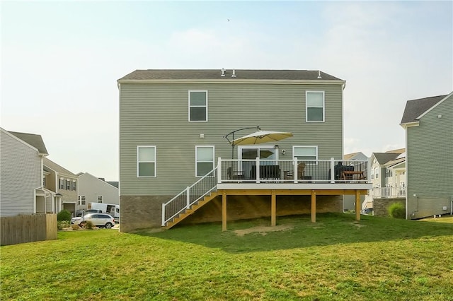 back of property with a lawn and a wooden deck