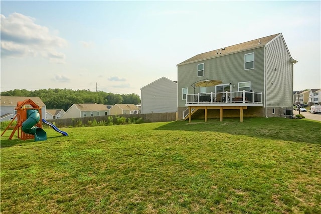 rear view of house featuring a lawn and a deck