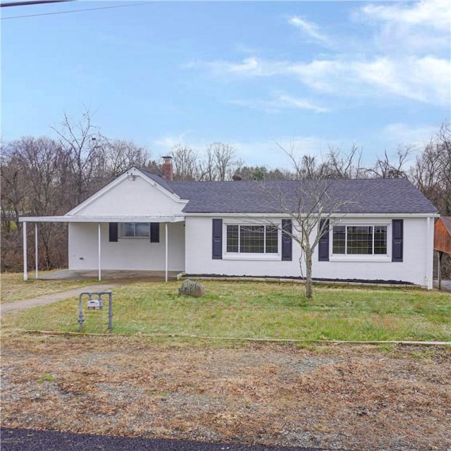 ranch-style home featuring a front lawn and a carport