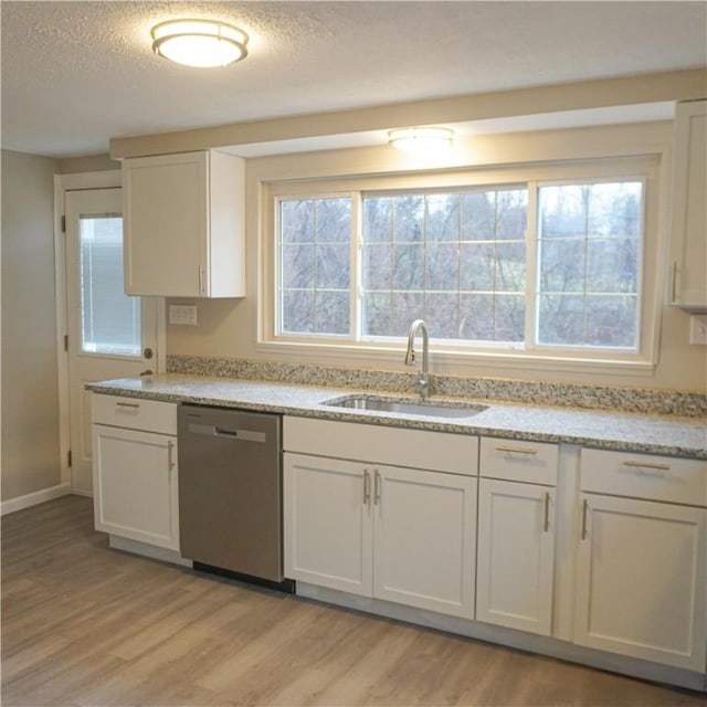 kitchen featuring dishwasher, white cabinets, light hardwood / wood-style flooring, and sink