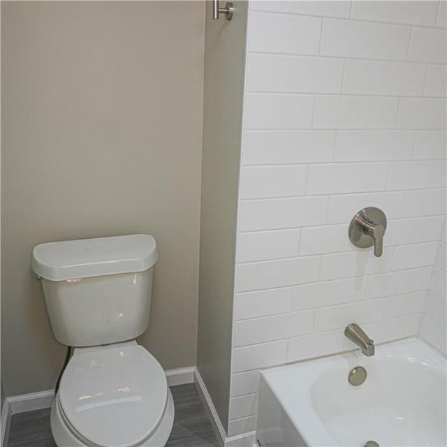 bathroom with hardwood / wood-style floors, shower / bath combination, and toilet