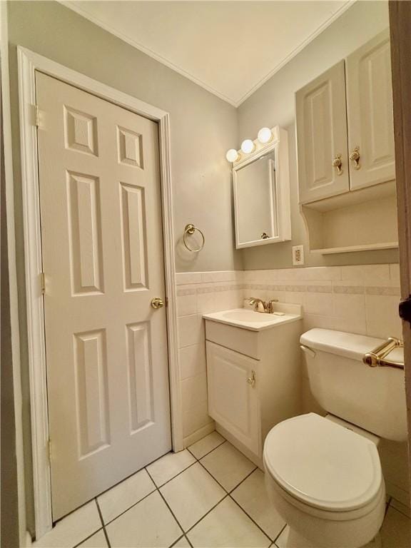 bathroom with vanity, crown molding, tile walls, tile patterned flooring, and toilet