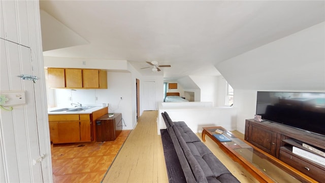 interior space featuring ceiling fan, light wood-type flooring, and sink