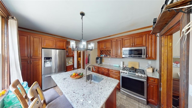 kitchen featuring sink, crown molding, pendant lighting, a kitchen island with sink, and appliances with stainless steel finishes