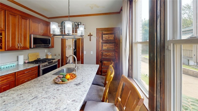 kitchen featuring a breakfast bar, crown molding, sink, appliances with stainless steel finishes, and a notable chandelier