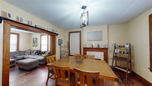 dining room with dark hardwood / wood-style flooring and a fireplace