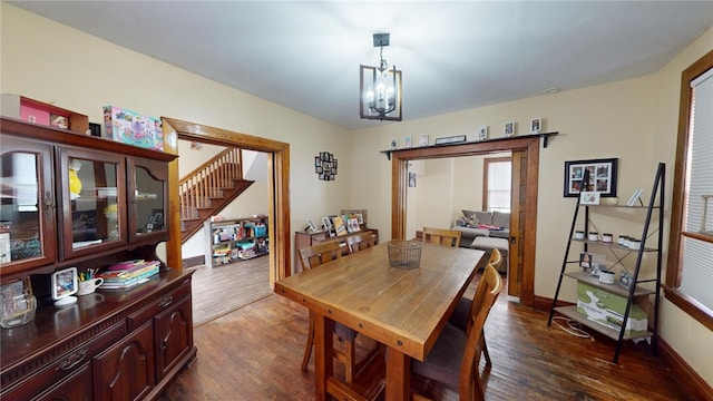 dining space with dark wood-type flooring and a chandelier