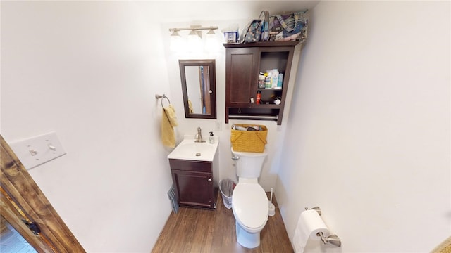 bathroom featuring vanity, wood-type flooring, and toilet