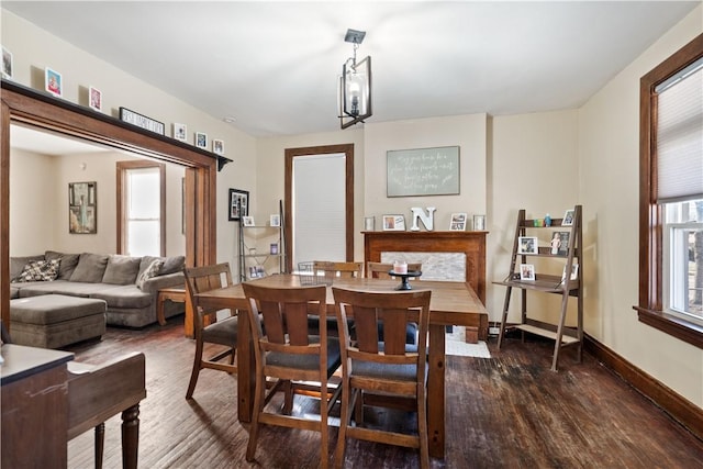 dining space featuring dark wood-style floors and baseboards