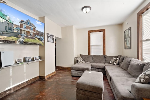 living area featuring plenty of natural light, hardwood / wood-style flooring, and baseboards