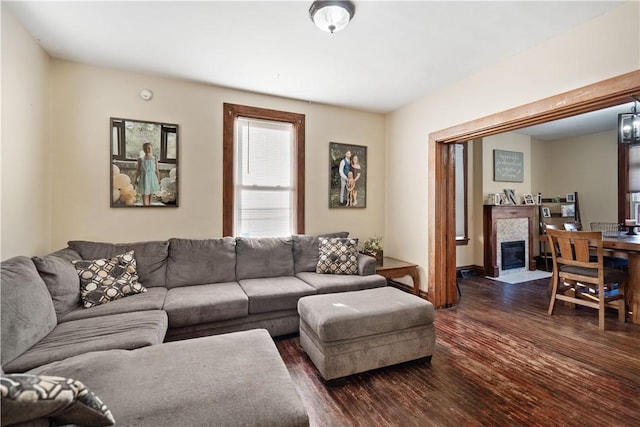 living area featuring a fireplace with flush hearth and dark wood-type flooring
