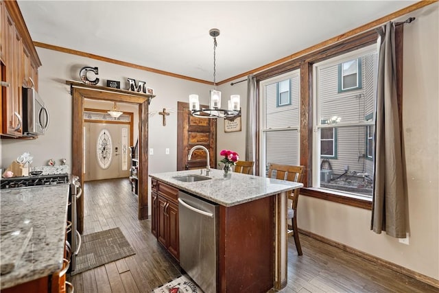 kitchen featuring a center island with sink, appliances with stainless steel finishes, a sink, and dark wood-style floors