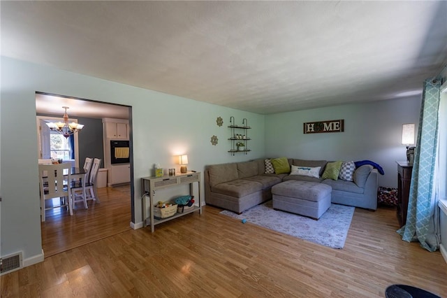 living room with an inviting chandelier and hardwood / wood-style flooring