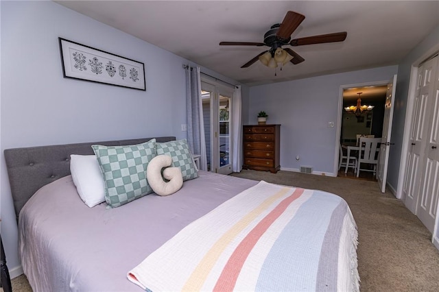 bedroom with carpet flooring, a closet, and ceiling fan with notable chandelier