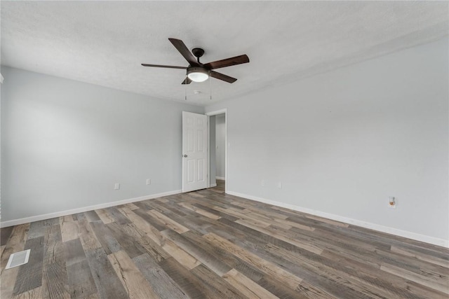 spare room featuring ceiling fan and dark wood-type flooring