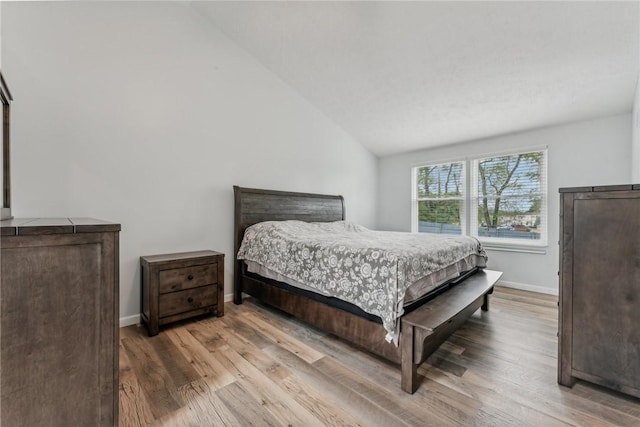 bedroom featuring light hardwood / wood-style flooring and vaulted ceiling