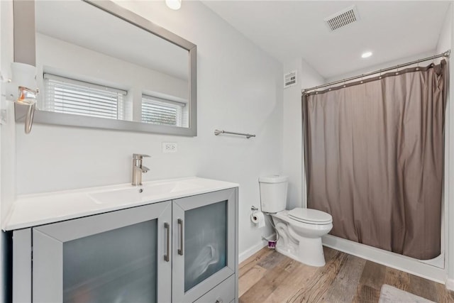 bathroom with hardwood / wood-style floors, vanity, a shower with shower curtain, and toilet