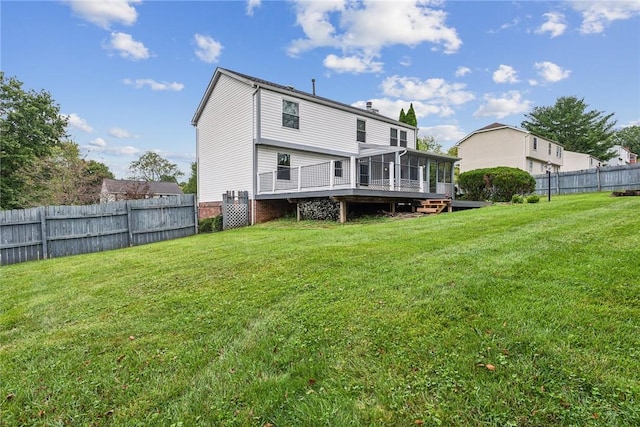 back of property featuring a lawn, a wooden deck, and a sunroom