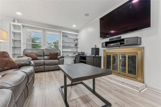 living room with a fireplace, light hardwood / wood-style flooring, and crown molding