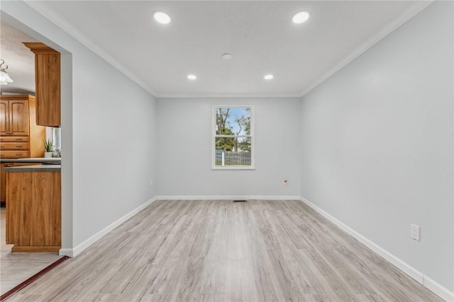 unfurnished room featuring light hardwood / wood-style flooring and ornamental molding