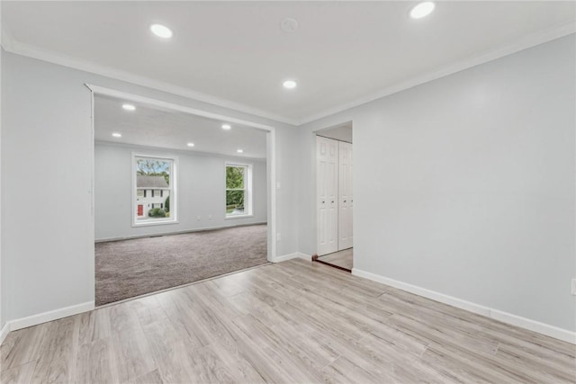 spare room with crown molding and light hardwood / wood-style flooring