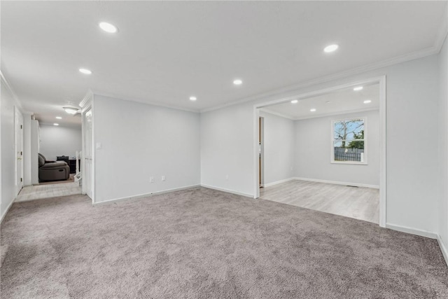 empty room with crown molding and light colored carpet