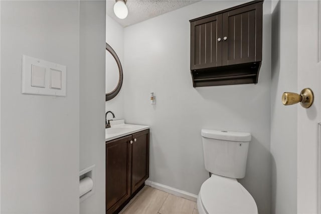 bathroom featuring vanity, a textured ceiling, and toilet