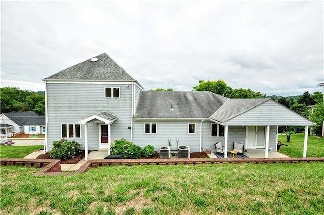 back of property with a yard, a patio, and central air condition unit