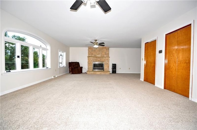 unfurnished living room featuring ceiling fan, carpet floors, and a fireplace