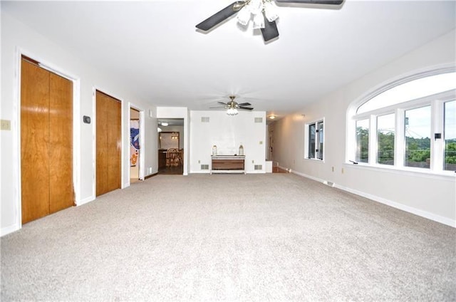 unfurnished living room with carpet and ceiling fan