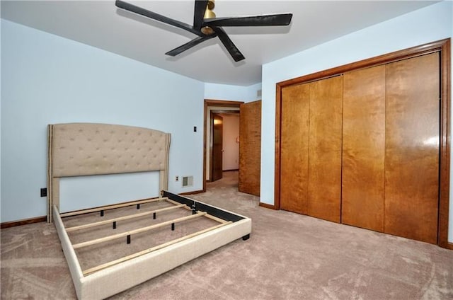 unfurnished bedroom featuring ceiling fan, a closet, and carpet