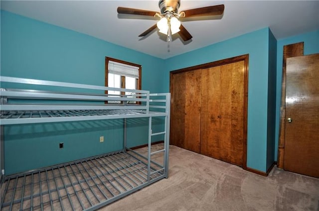 unfurnished bedroom with ceiling fan, a closet, and carpet floors