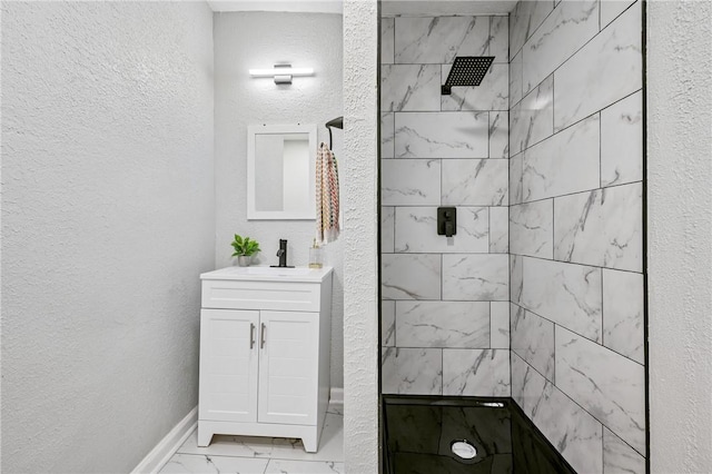 bathroom featuring a tile shower and vanity