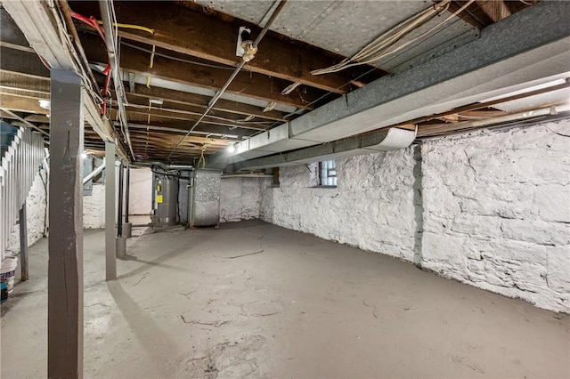 basement featuring heating unit and water heater